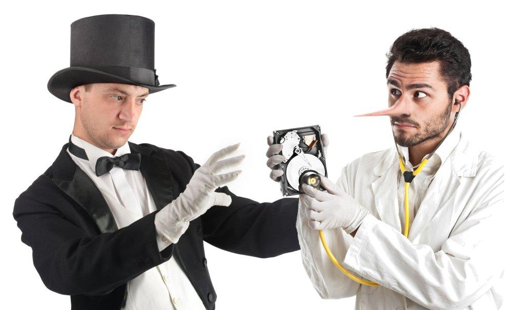 Mago e medico esaminano un hard disk — metafora del recupero dati